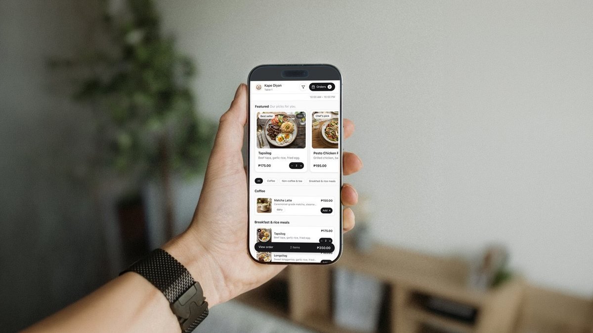 A hand holding a phone showing a restaurant menu